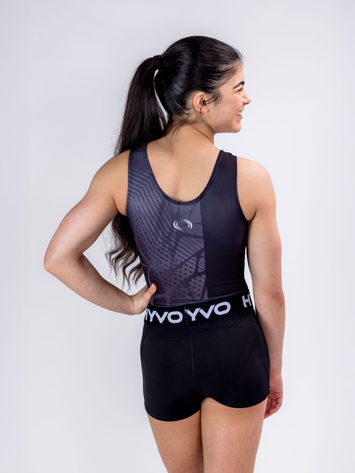 Back view of black girls gymnastics leotard from the HYVO Evolve range styled with black gymnastics shorts