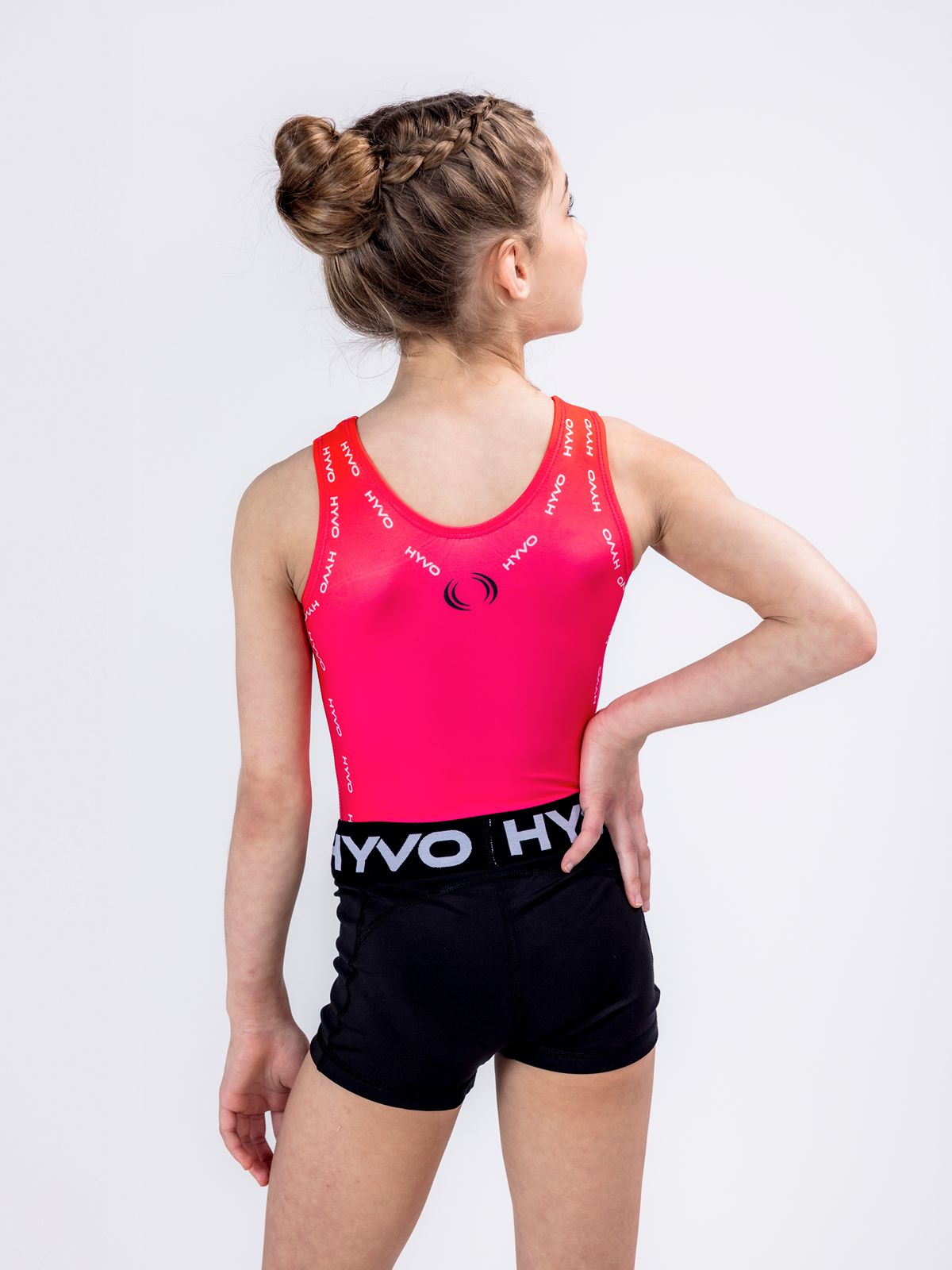 Back view of burnt orange girls gymnastics leotard from the HYVO Rise Up range styled with black gymnastics shorts