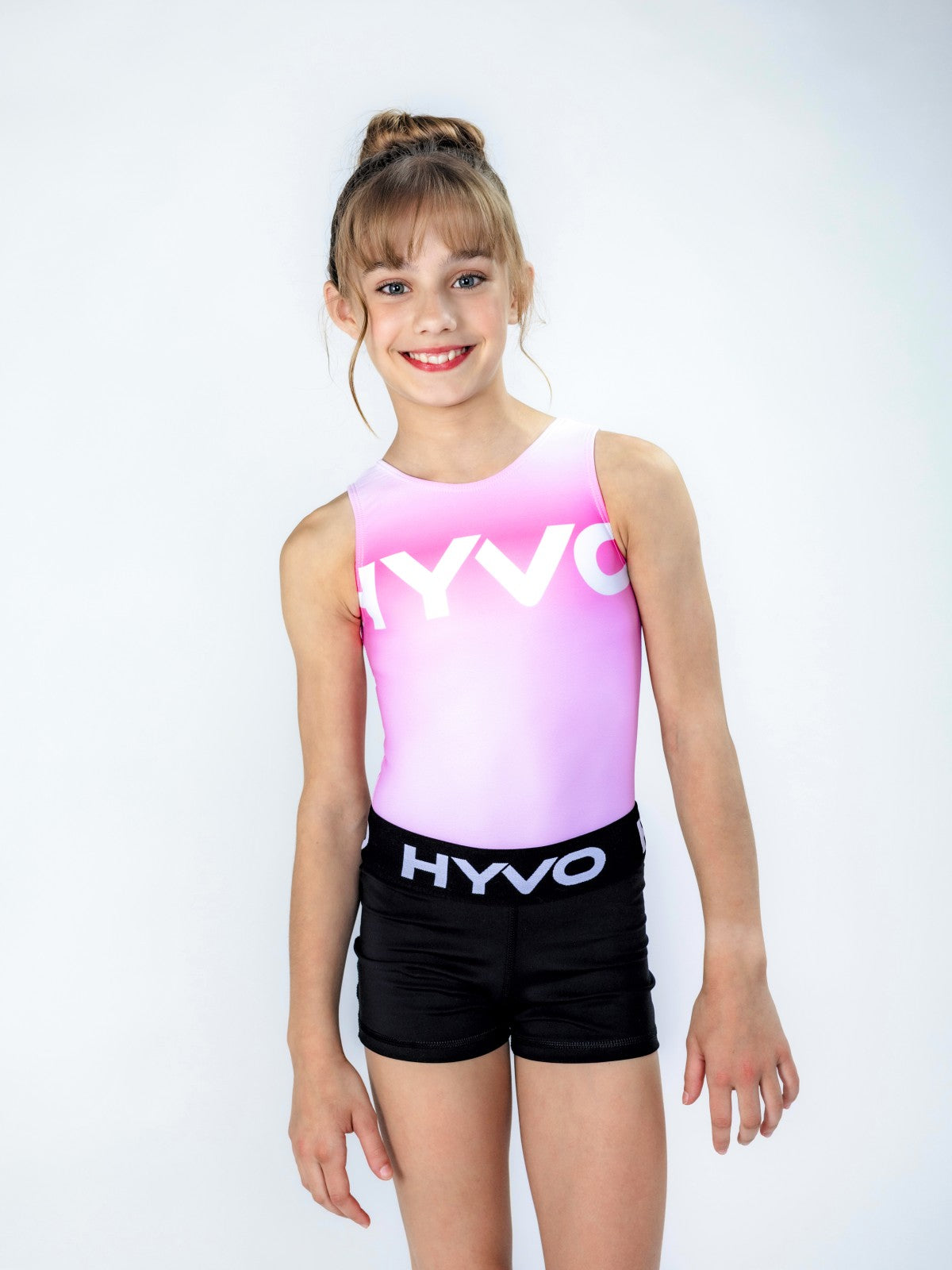 Front view of pretty pink girls gymnastics leotard from the HYVO Ascend range styled with gymnastics shorts